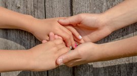 Vier Hände halten sich aneinander fest