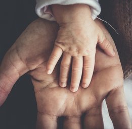 Babyhand auf erwachsener Hand